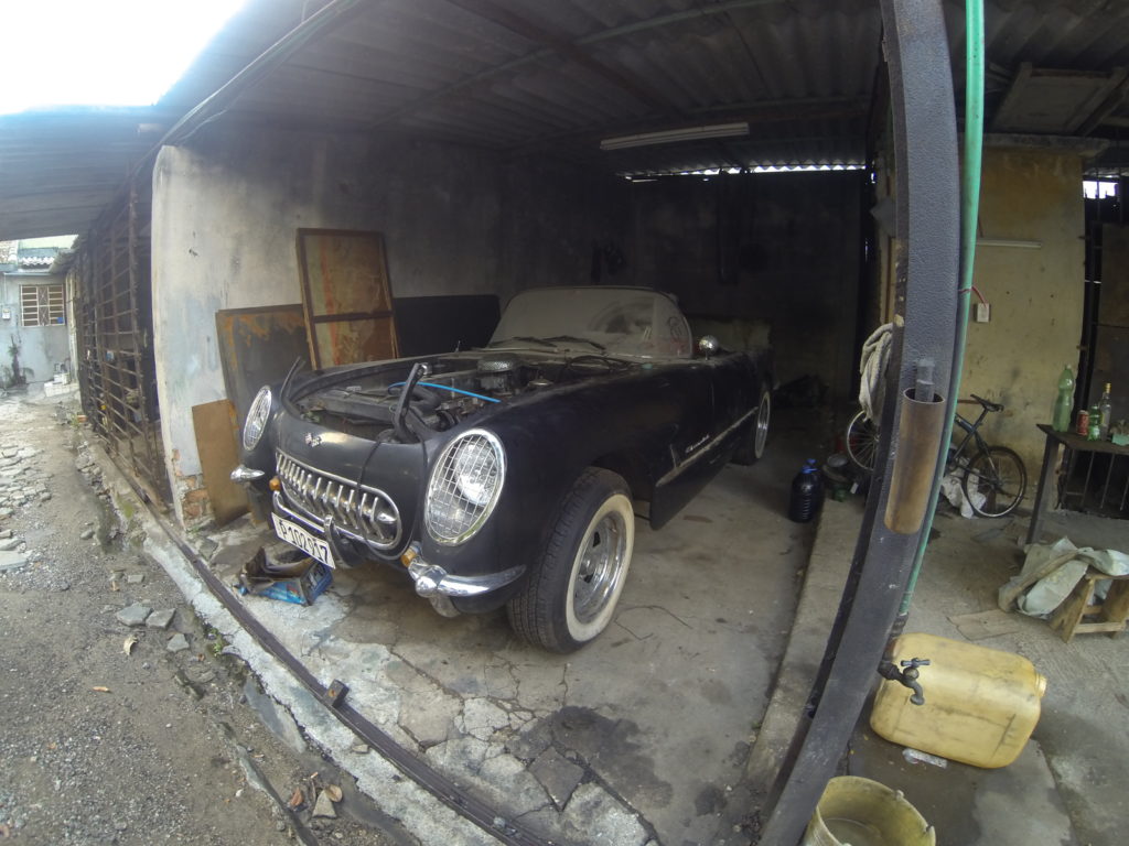 A black Corvette sits in a private mechanic's shop, Havana, Cuba
