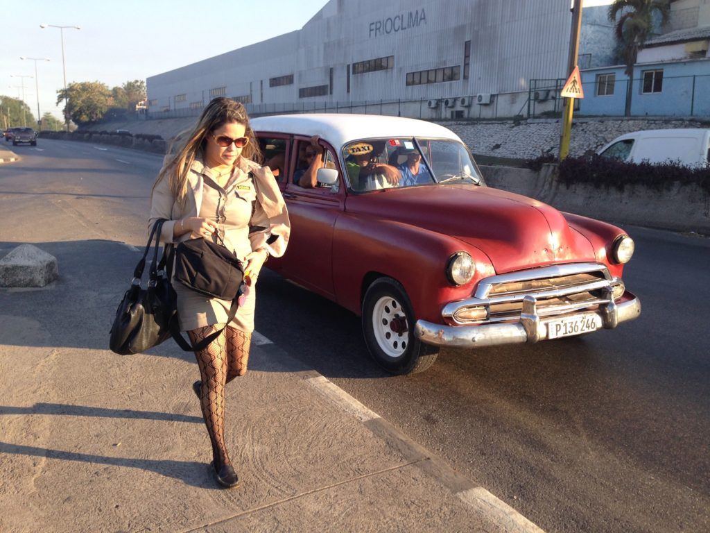 I treasure this picture, which captures two fun pieces of Cuban culture: a máquina and a professional accessorizing her work uniform with fishnets. I need to devote an upcoming post to Cuban fishnet fashion... love it!