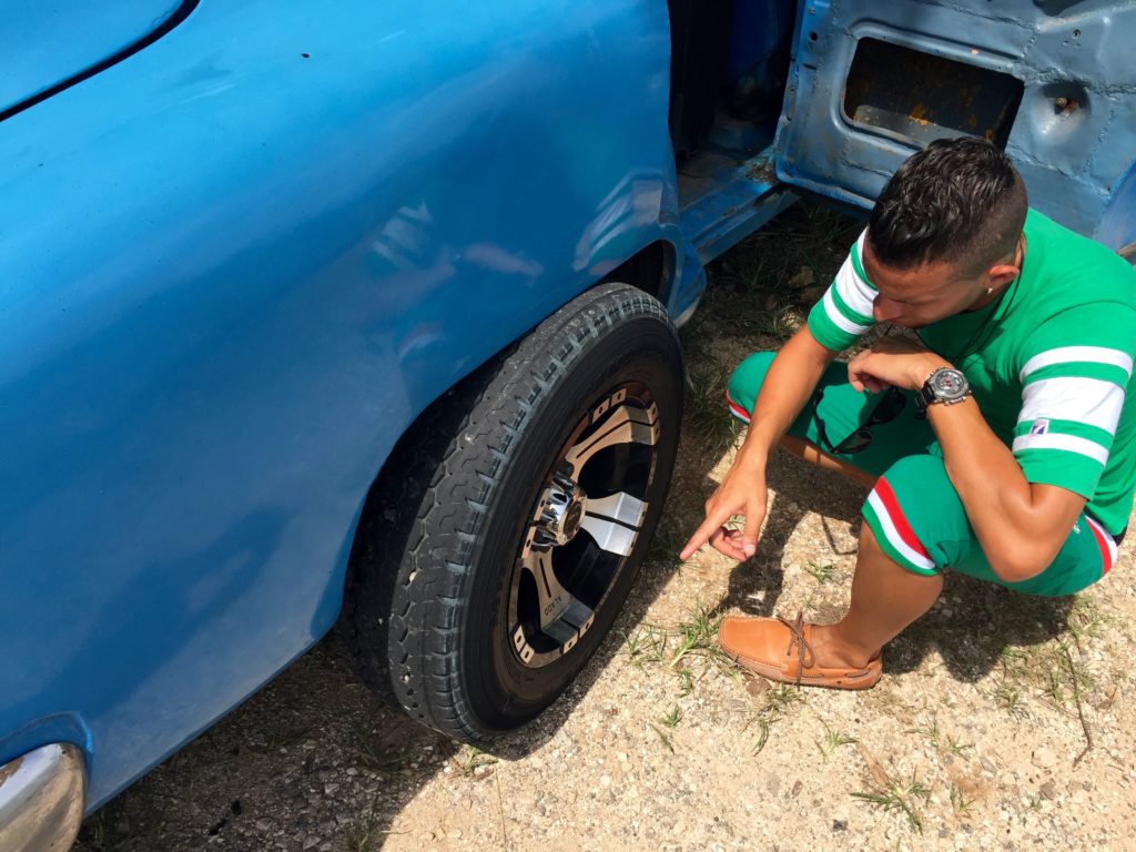 Dayron checks out the broken down car.