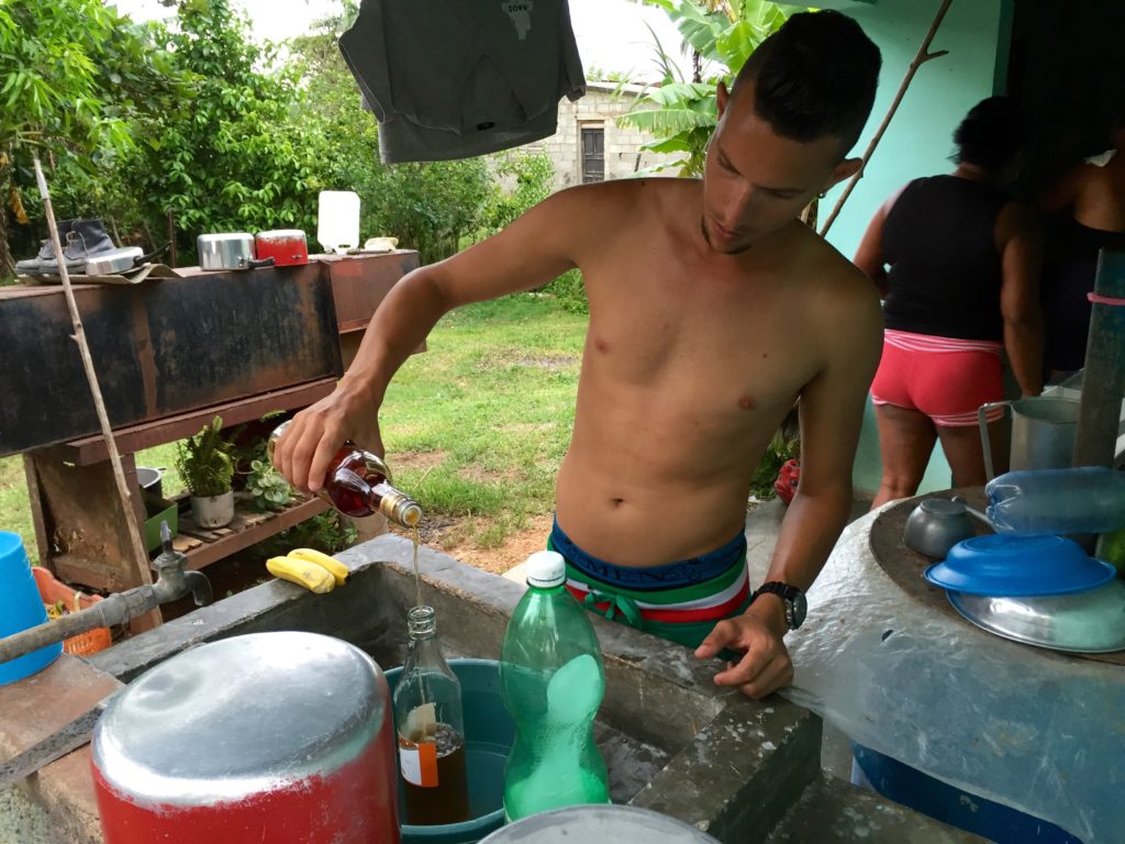 Dayron pours Havana Club rum into a bottle of cheaper rum