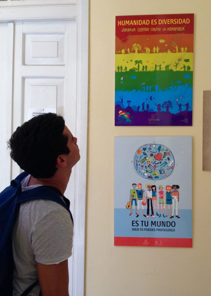 A man looks at colorful posters on the wall