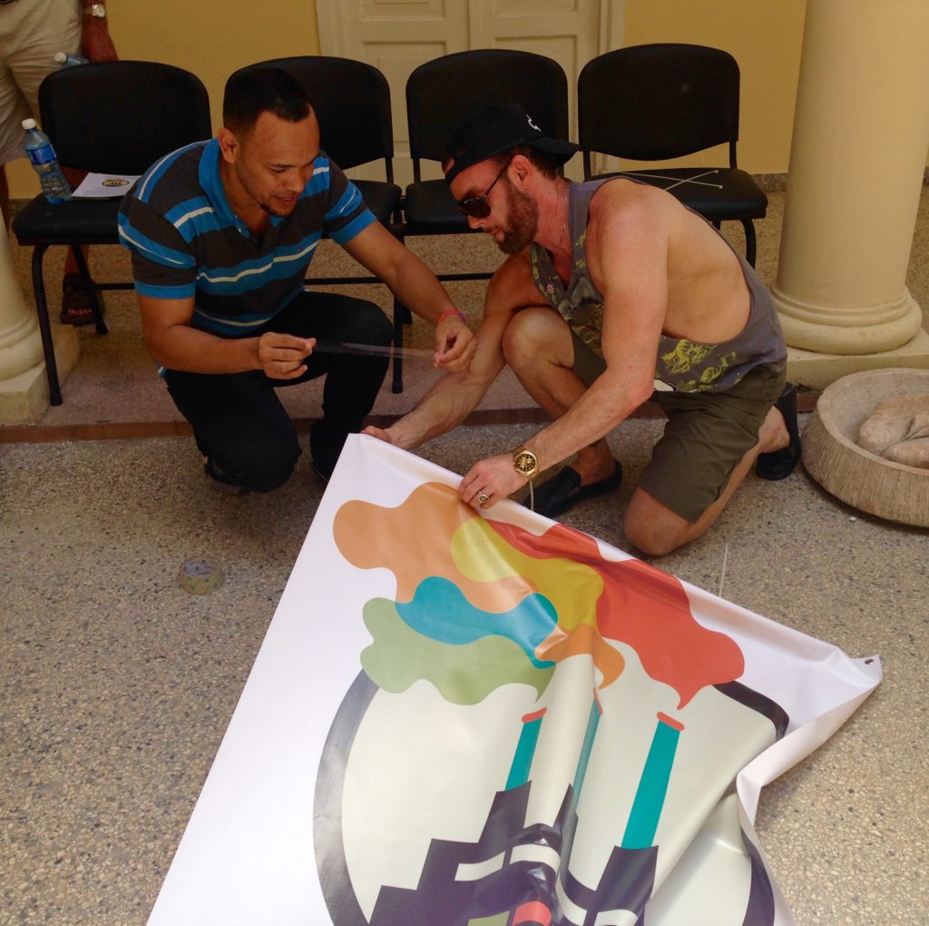 Two men work to hang a banner