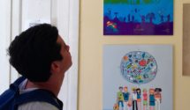 A man looks at colorful posters on the wall