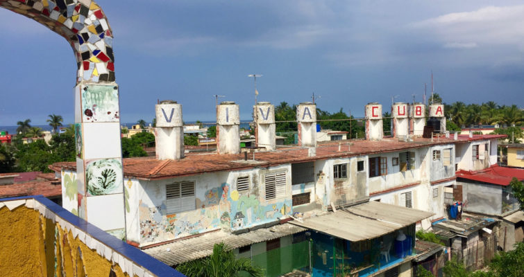A row of water tanks each is painted with one letter, spelling out Viva Cuba