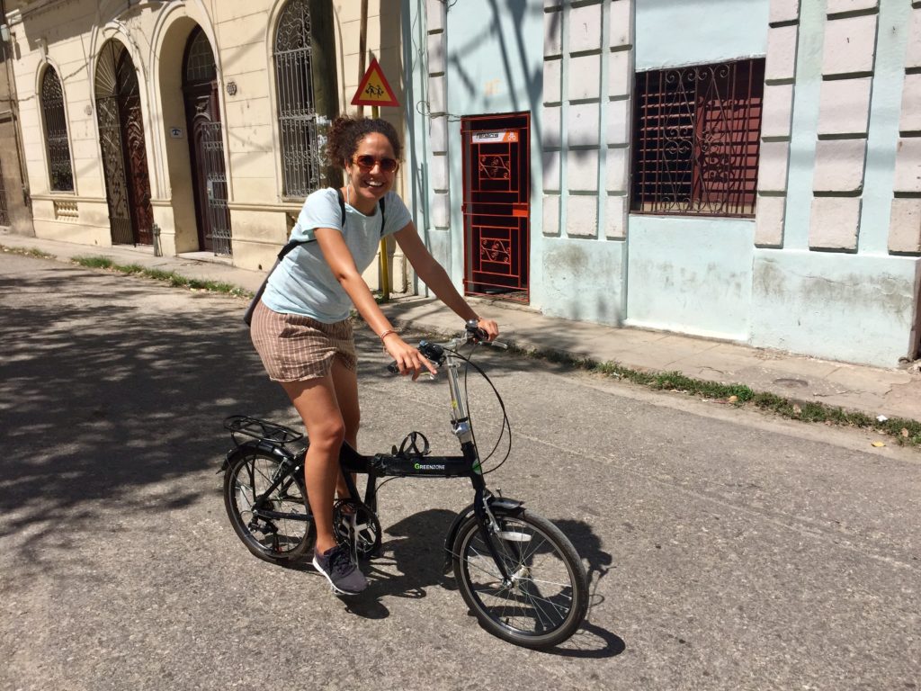 Woman sits on a bike and smiles at the camera
