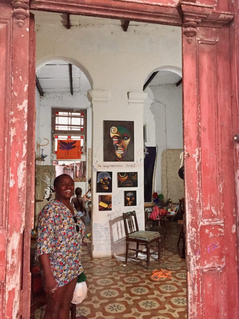 Woman stands in the open doorway of her home welcoming us in