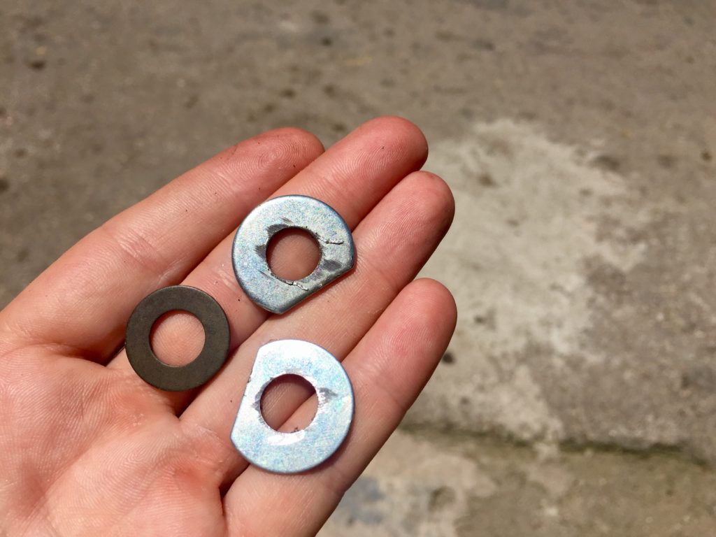 A hand holding three washers